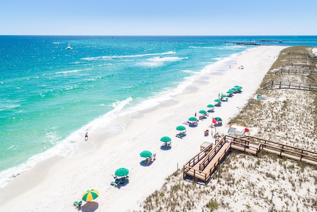 birds eye view of property with a water view and a beach view