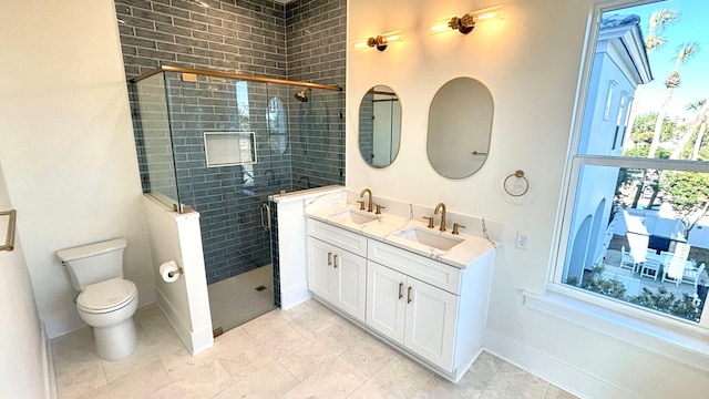 full bath with a sink, a shower stall, toilet, and double vanity