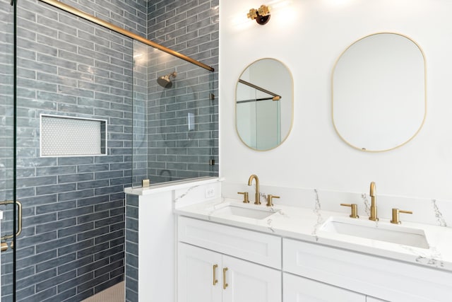 full bathroom with double vanity, a tile shower, and a sink