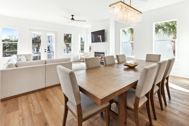 dining space featuring french doors, visible vents, a fireplace, and light wood-style flooring