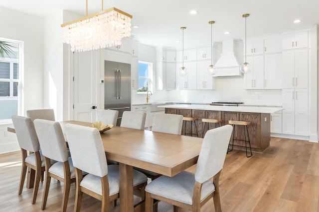 dining space with light wood-type flooring, an inviting chandelier, and recessed lighting