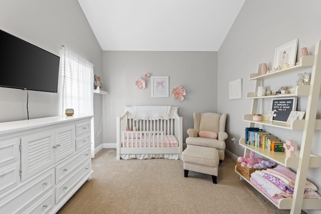 bedroom with lofted ceiling, a nursery area, light carpet, and baseboards