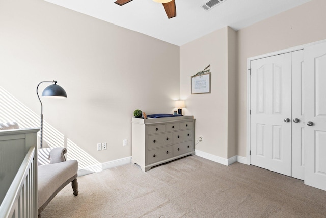 carpeted bedroom featuring a ceiling fan, a closet, visible vents, and baseboards