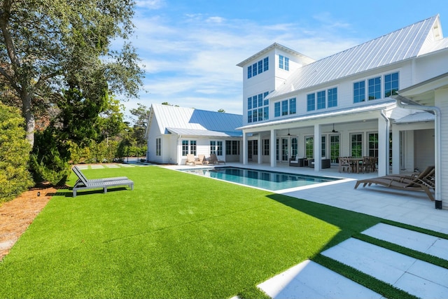 back of property featuring a patio area, a yard, metal roof, and french doors