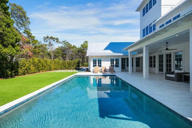 view of pool with a fenced in pool, a patio area, a lawn, and ceiling fan