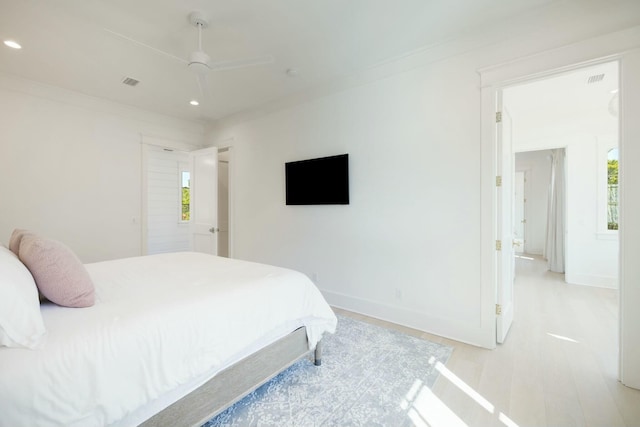 bedroom featuring baseboards, ornamental molding, light wood-type flooring, and recessed lighting