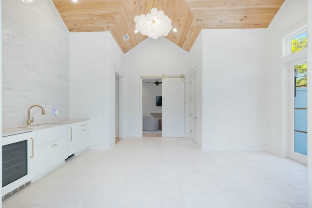 interior space with high vaulted ceiling, wooden ceiling, beverage cooler, a sink, and white cabinetry