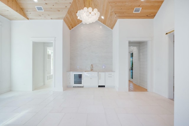 interior space with beverage cooler, visible vents, lofted ceiling, and wood ceiling