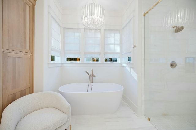 bathroom featuring a freestanding bath, tiled shower, a chandelier, and baseboards