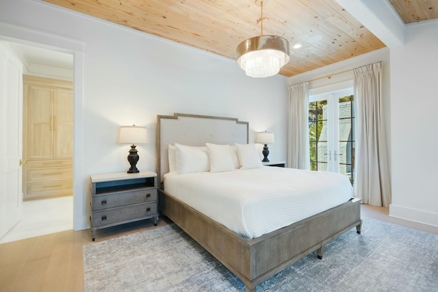 bedroom with baseboards, wooden ceiling, wood finished floors, and access to exterior