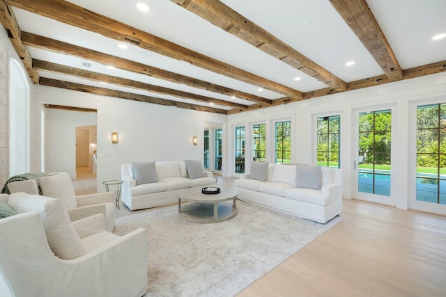 living area featuring light wood finished floors, beamed ceiling, and recessed lighting