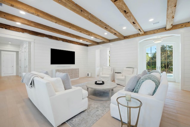 living room with wooden walls, visible vents, wood finished floors, beam ceiling, and recessed lighting