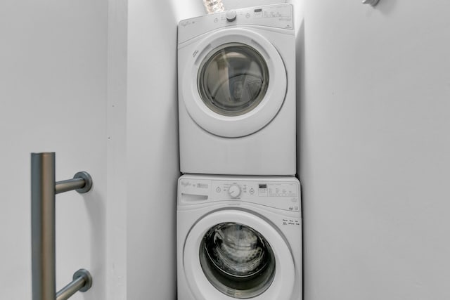 clothes washing area featuring laundry area and stacked washer / dryer