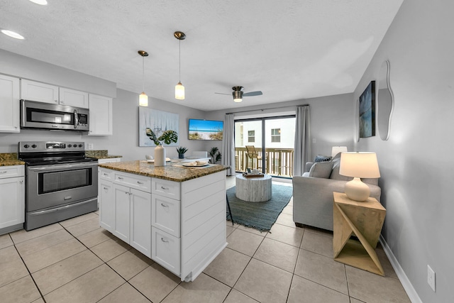 kitchen featuring white cabinets, light tile patterned floors, dark stone counters, and stainless steel appliances