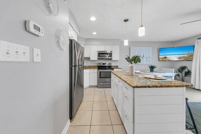 kitchen featuring light tile patterned floors, white cabinetry, stainless steel appliances, and a center island