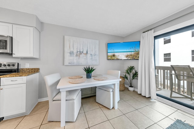 dining room featuring baseboards, breakfast area, and light tile patterned flooring