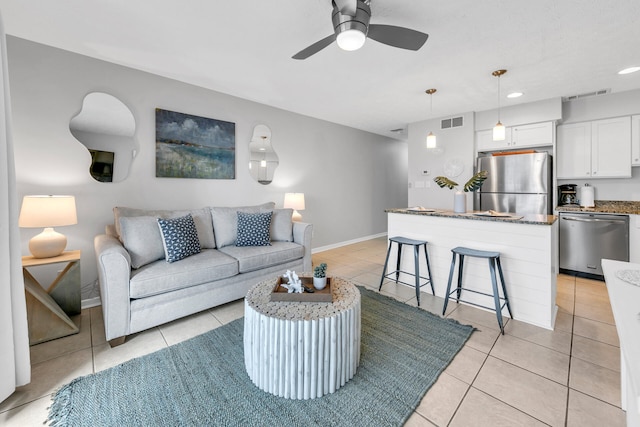 living room with visible vents, ceiling fan, baseboards, and light tile patterned floors