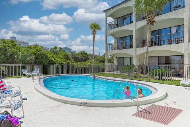 community pool featuring a patio area and fence