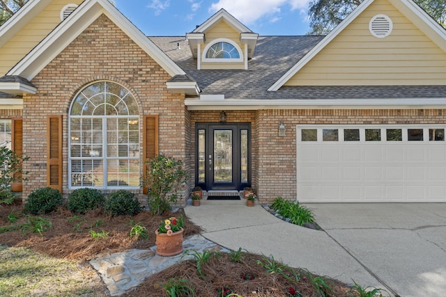 view of front of home featuring a garage, brick siding, driveway, and roof with shingles