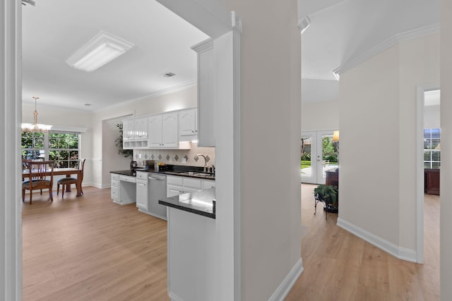 kitchen featuring decorative backsplash, white cabinets, dishwasher, dark countertops, and a sink