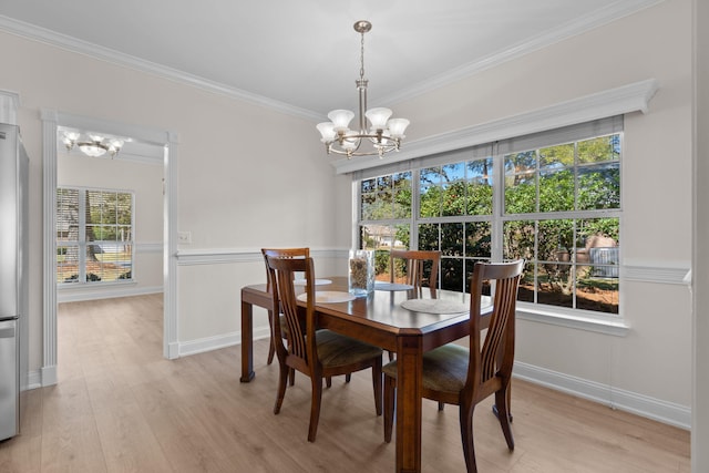 dining space featuring light wood-style floors, baseboards, a chandelier, and ornamental molding