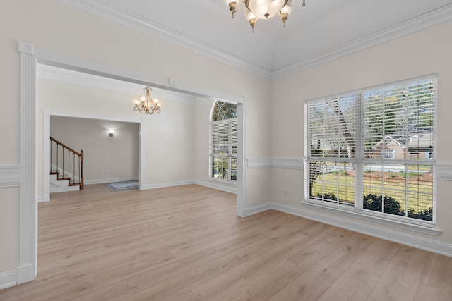 empty room featuring a chandelier, light wood-style floors, stairway, and baseboards