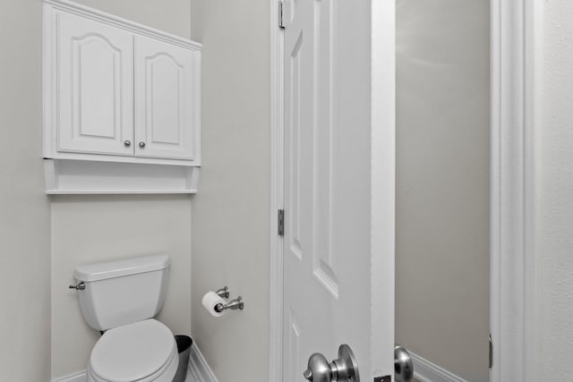 bathroom with toilet and baseboards