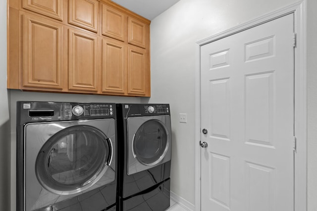 washroom with cabinet space, baseboards, and independent washer and dryer