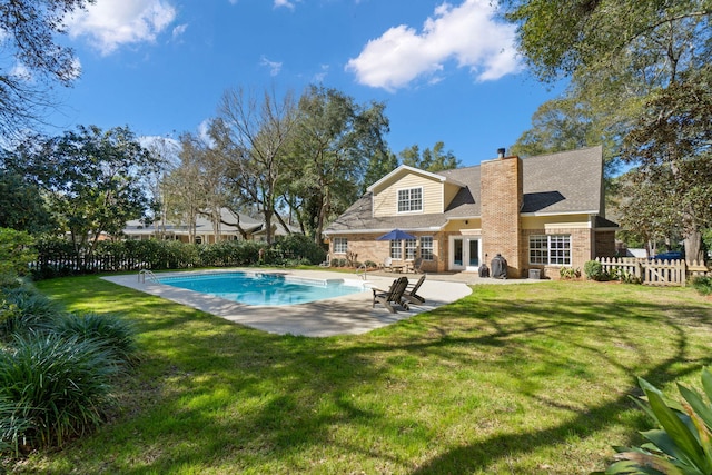 view of pool with a patio area, fence, a fenced in pool, and a yard