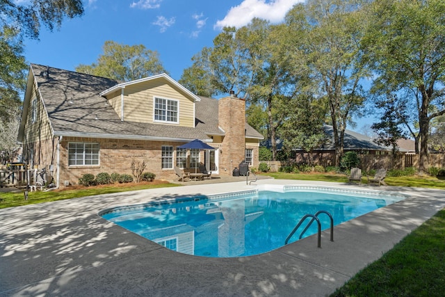 view of swimming pool featuring a fenced in pool, a patio, a lawn, and fence