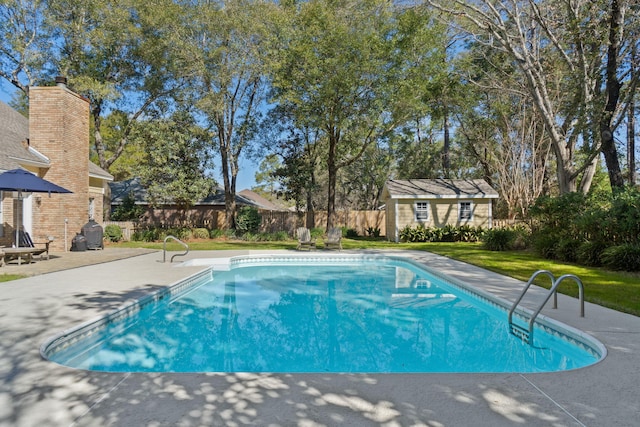 view of pool with a fenced in pool, an outbuilding, fence, a yard, and a patio area