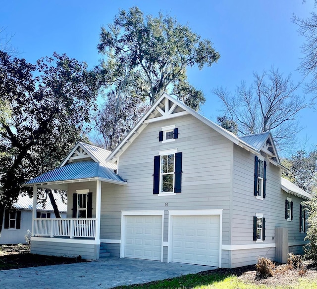 view of front of house with covered porch, metal roof, and an attached garage