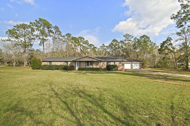 ranch-style home featuring an attached garage and a front yard