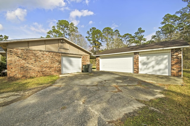 exterior space featuring a garage and brick siding