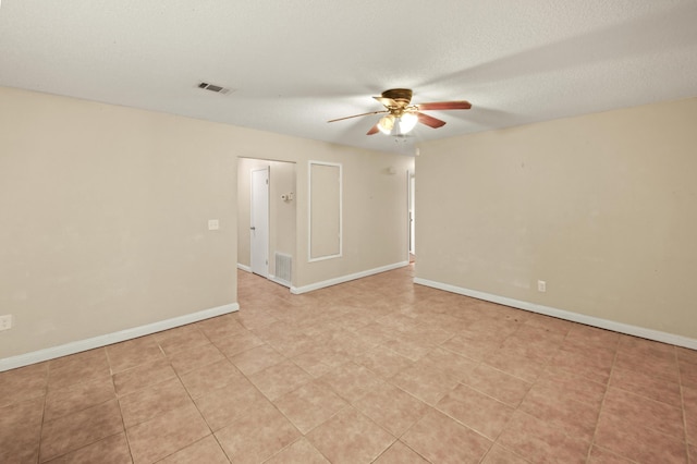 empty room featuring baseboards, visible vents, and ceiling fan