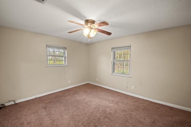 carpeted spare room featuring a ceiling fan, baseboards, and a textured ceiling