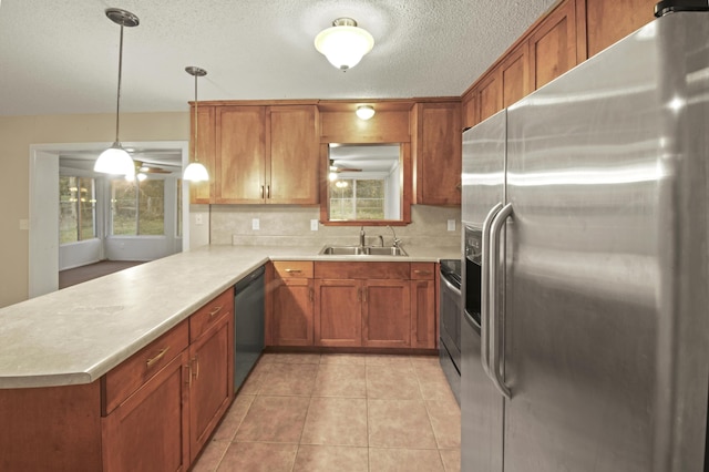 kitchen featuring appliances with stainless steel finishes, light countertops, a sink, and light tile patterned floors