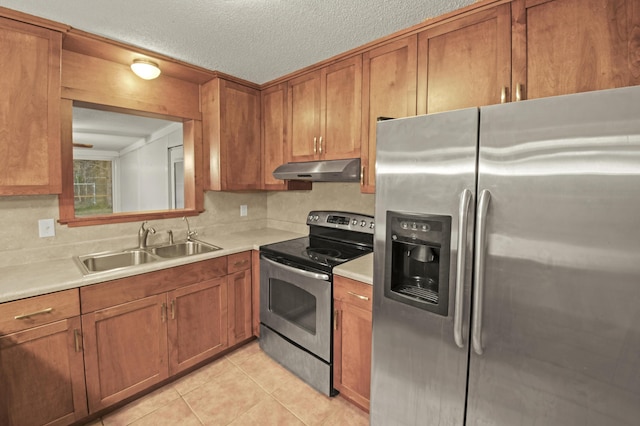 kitchen featuring stainless steel appliances, brown cabinets, a sink, and under cabinet range hood