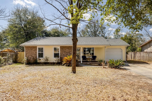 ranch-style home with an attached garage, driveway, fence, and roof with shingles