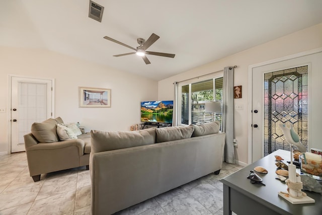 living area featuring lofted ceiling, visible vents, and a ceiling fan