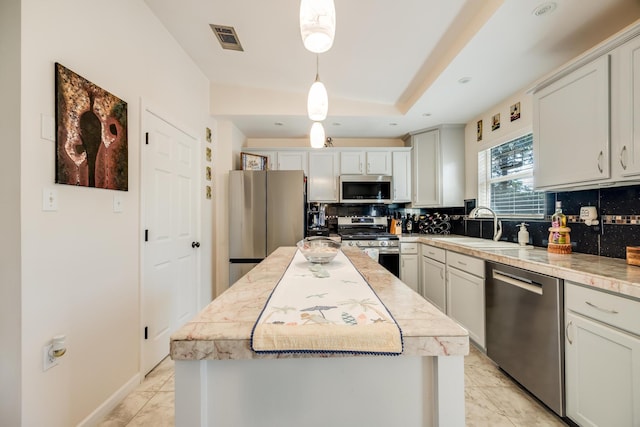 kitchen with visible vents, appliances with stainless steel finishes, tasteful backsplash, and a sink