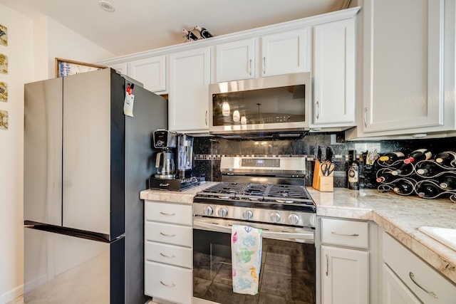 kitchen featuring appliances with stainless steel finishes, white cabinets, and tasteful backsplash