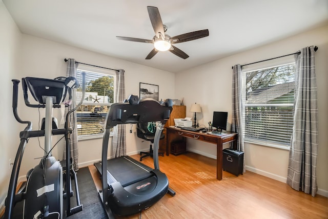 workout area with a ceiling fan, baseboards, and wood finished floors