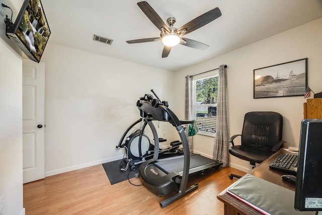 workout room featuring baseboards, visible vents, ceiling fan, and wood finished floors