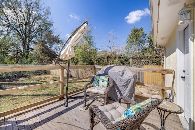 wooden terrace with a fenced backyard