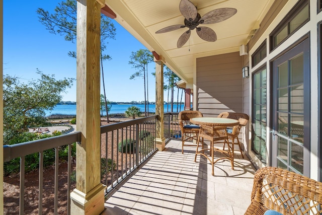 balcony with a water view and a ceiling fan