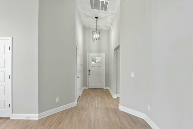 foyer with baseboards, a chandelier, visible vents, and light wood-style floors