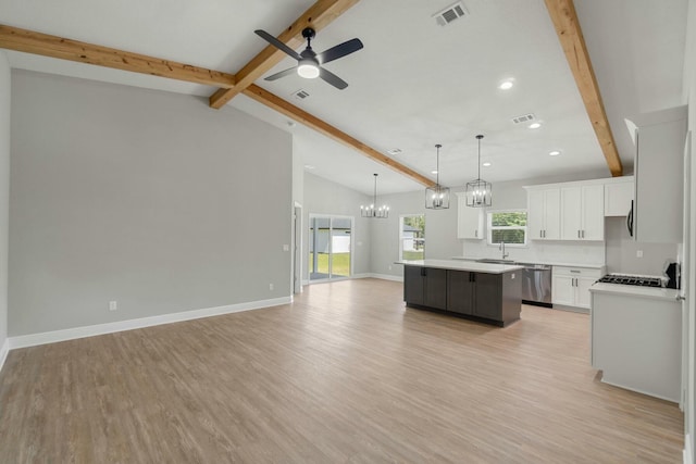 kitchen with visible vents, dishwasher, open floor plan, beamed ceiling, and a center island