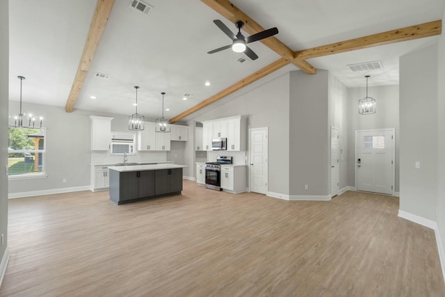 kitchen with beam ceiling, light wood finished floors, stainless steel appliances, visible vents, and white cabinets