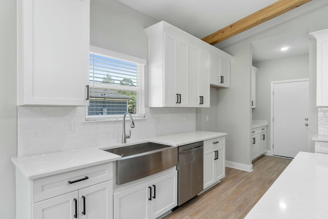 kitchen with tasteful backsplash, light wood-style flooring, stainless steel dishwasher, white cabinetry, and a sink